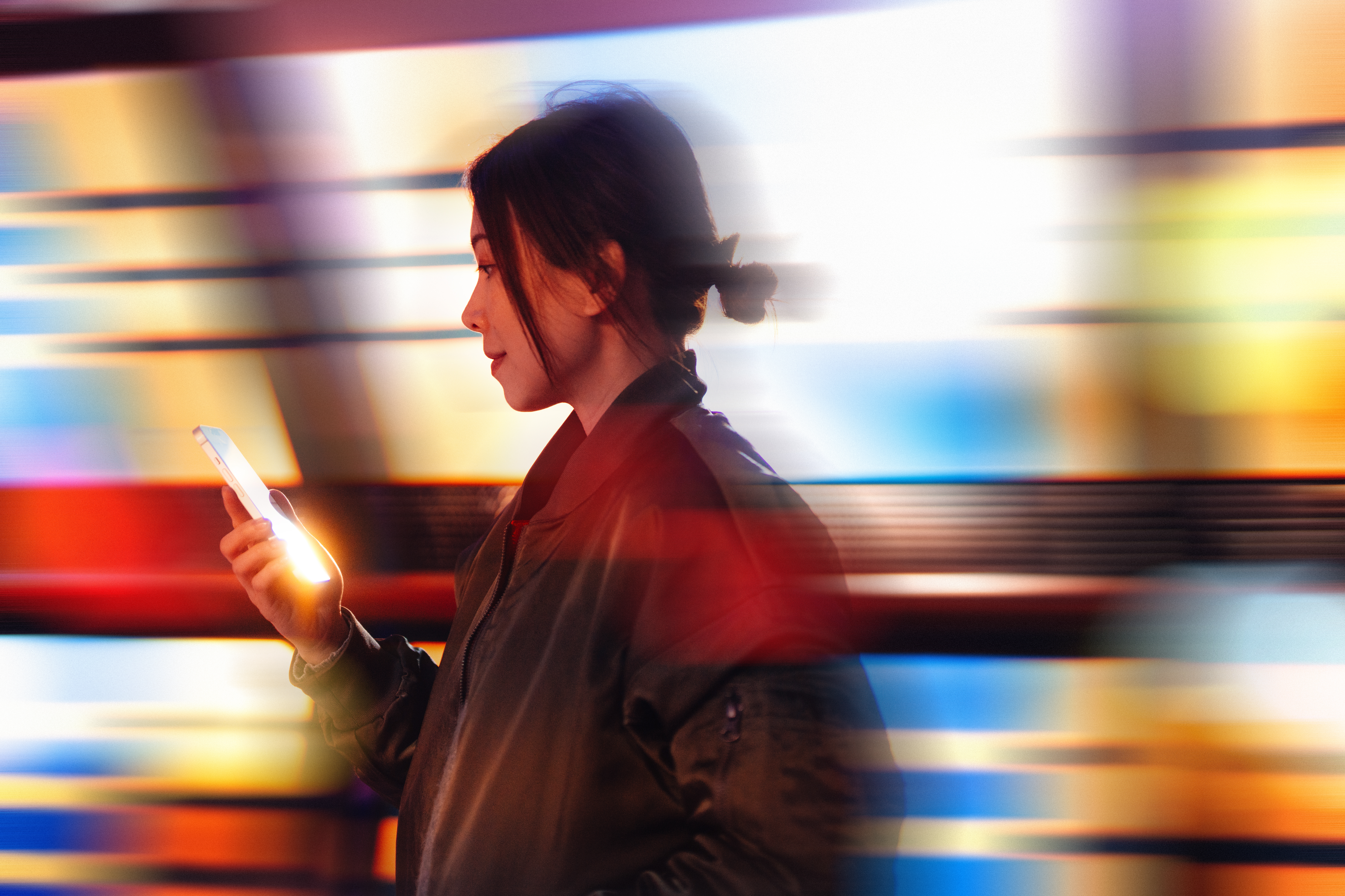 Young Asian woman using smartphone in a Virtual Reality (VR) environment