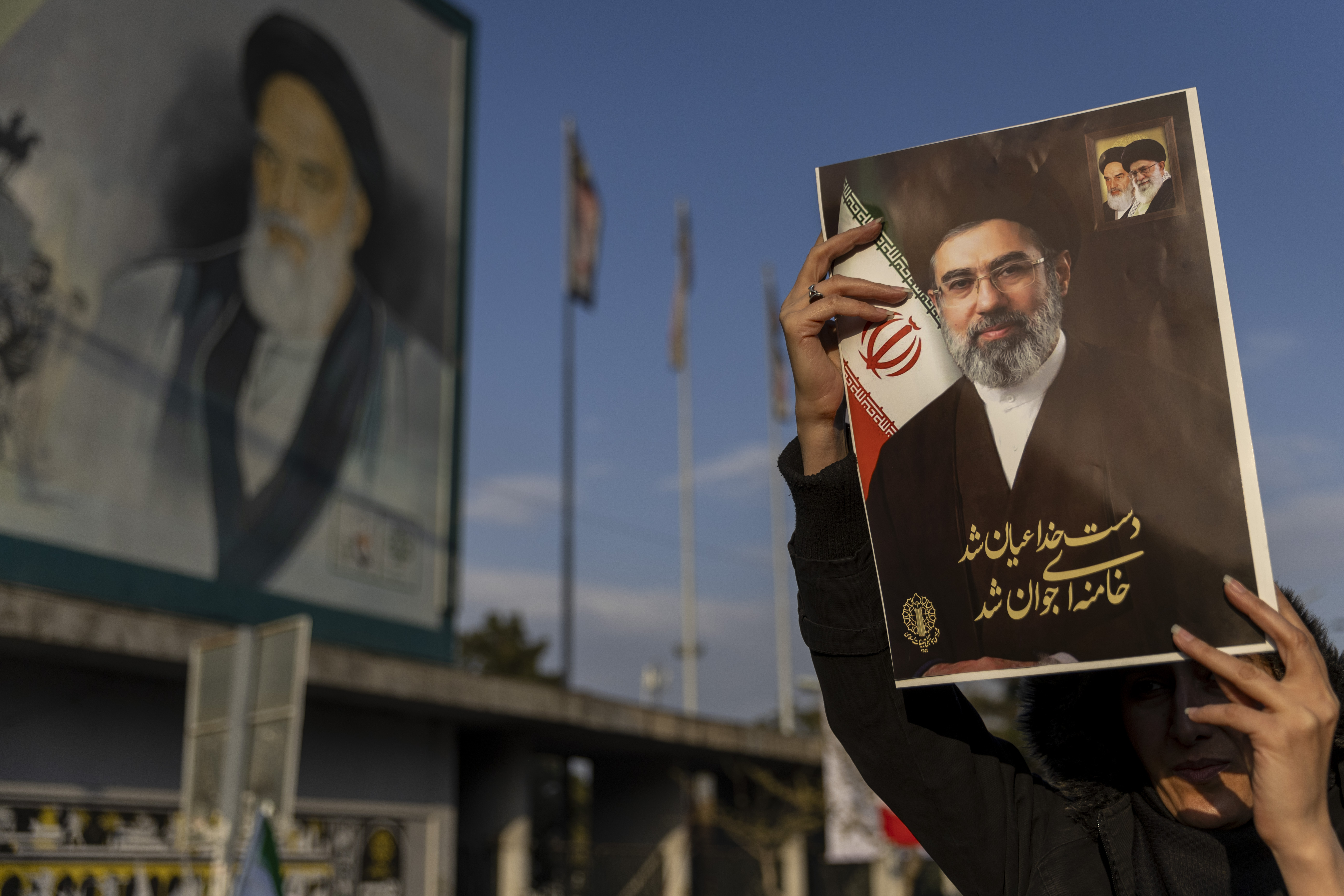 Mulher iraniana segura cartaz com a foto do líder supremo aiatolá Mojtaba Khamenei