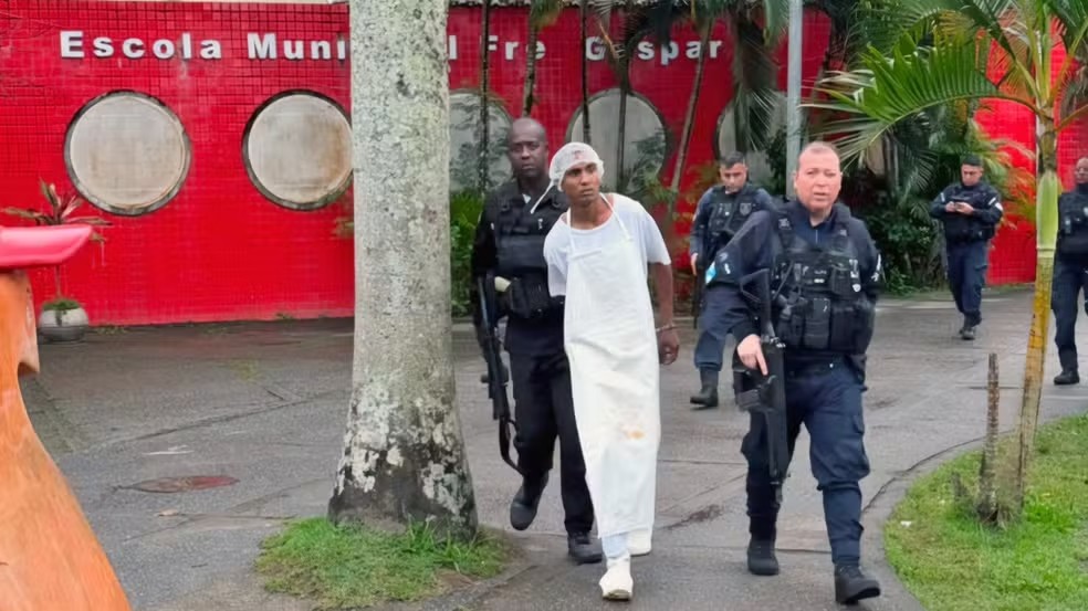 Homem armado com fuzil invade escola e veste uniforme de merendeiro para despistar a polícia