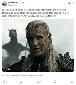 Homem de cabelos loiros longos, com o rosto e pesco&ccedil;o sujos de sangue e terra, vestindo armadura escura. Ele olha para frente com uma express&atilde;o s&eacute;ria. Ao fundo, uma figura escura com chifres, possivelmente um drag&atilde;o, sob um c&eacute;u nublado
