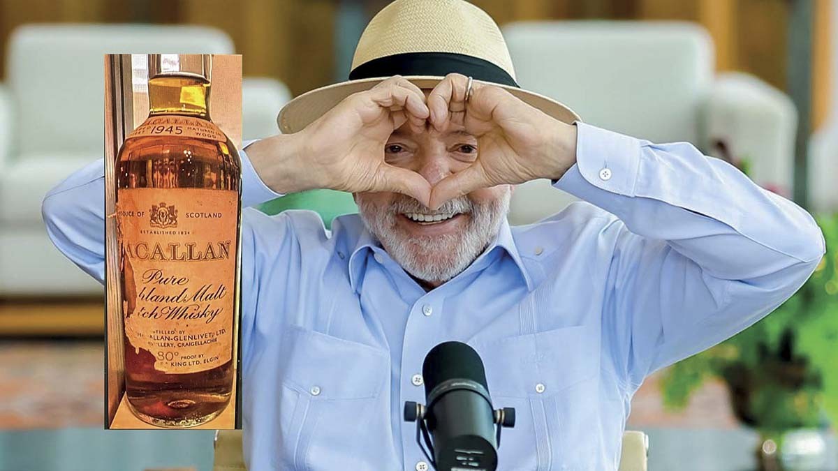 Lula sorrindo, usando chapéu de palha e camisa azul, faz um coração com as mãos sobre os olhos. À esquerda, uma garrafa de uísque Macallan Pure Island Malt 1945. Um microfone preto está à frente do presidente.