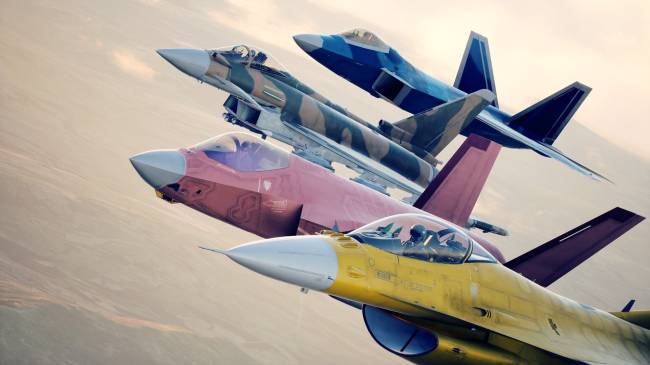 Quatro ca&ccedil;as militares voando em forma&ccedil;&atilde;o diagonal, com o c&eacute;u claro ao fundo. O avi&atilde;o mais pr&oacute;ximo &eacute; amarelo e branco, seguido por um rosa, um camuflado e um azul escuro. Todos t&ecirc;m pilotos vis&iacute;veis em seus cockpits
